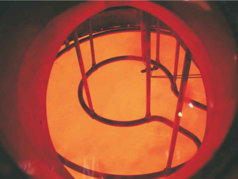 A photograph of the inside of the converter during reaction.  Once the reaction between ammonia and oxygen (in the air) is proceeding on the catalytic gauze, the exothermicity of the reaction sustains the temperature and the metal alloy glows red